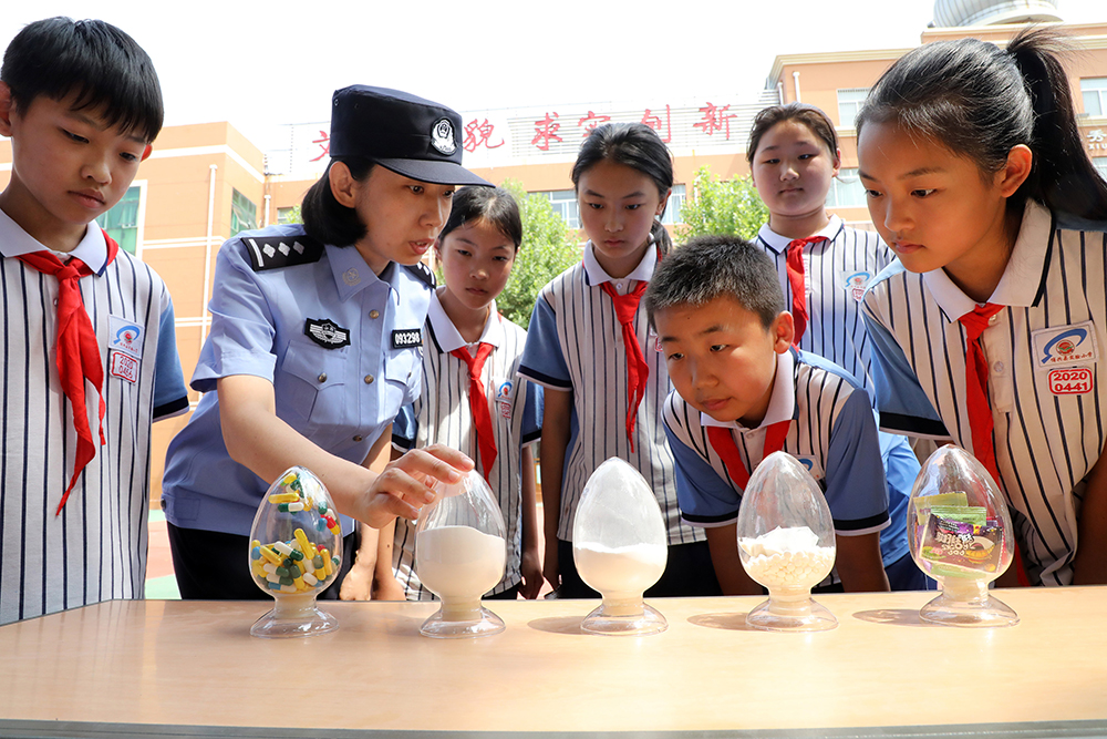 2025年6月24日，山东滨州博兴县公安局禁毒大队民警在博兴县实验小学通过毒品模型指导小学生辨认毒品。